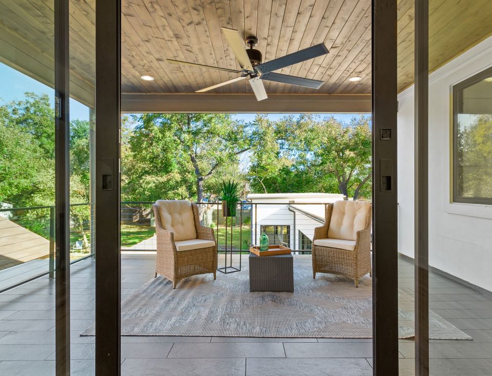 Outdoor patio scene with large black outdoor ceiling fan
